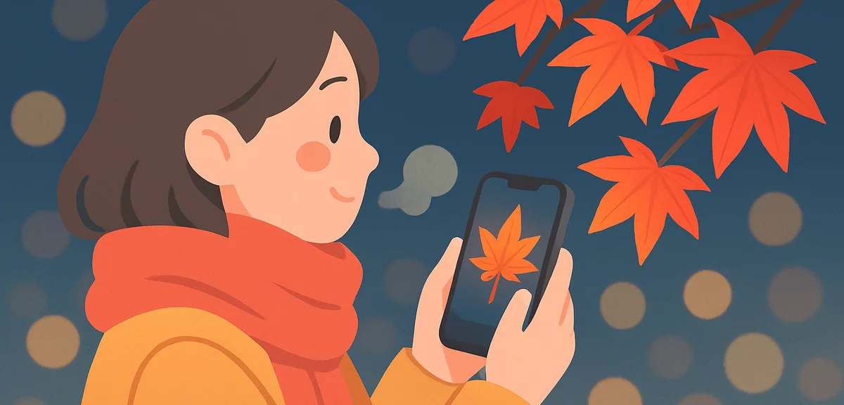 Person in a warm coat and scarf holding a smartphone photographing glowing red autumn maple leaves a